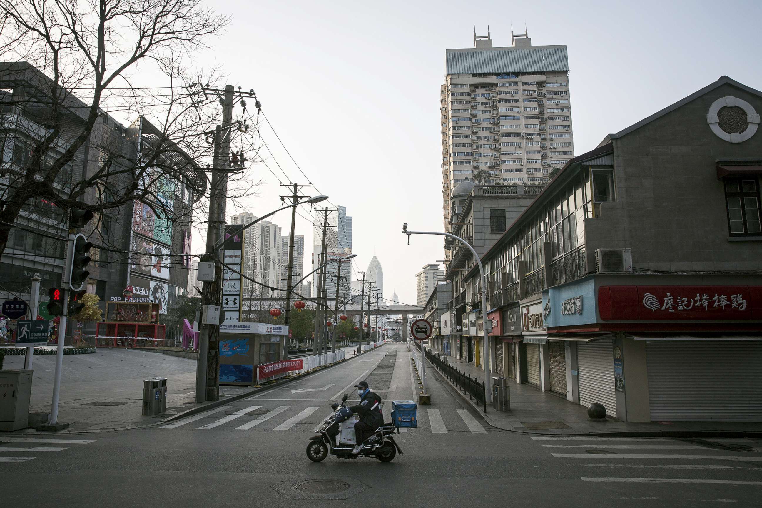 PHOTO: A man wears a protective mask as he rides a scooter on an empty business street, Feb. 13, 2020, in Wuhan, China.