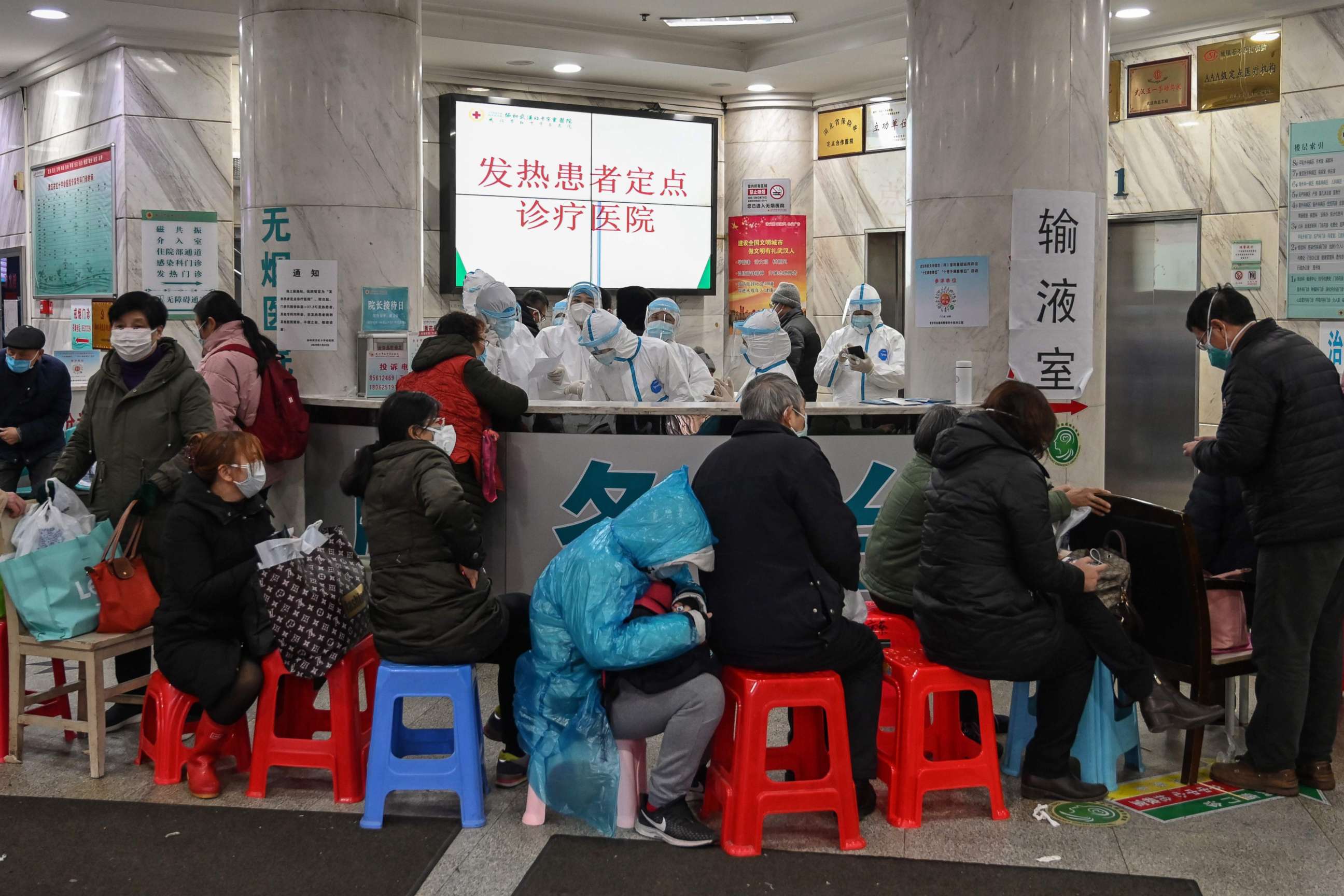 PHOTO: Medical staff in protective clothing help people who are waiting to be seen at the Wuhan Red Cross Hospital in Wuhan, China, Jan. 24, 2020.