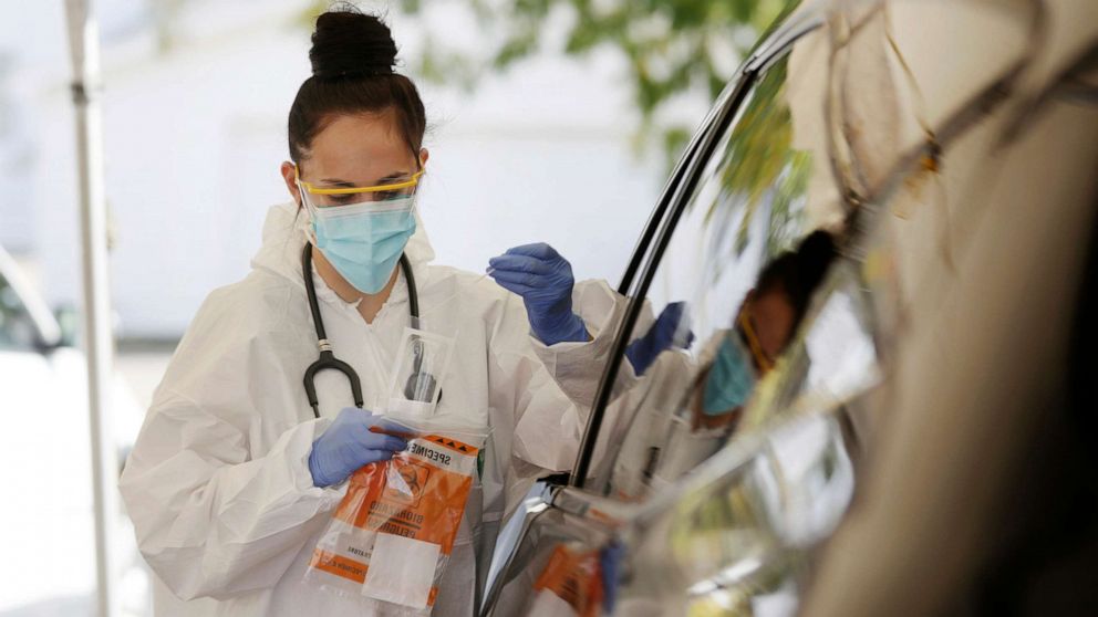 PHOTO: Medical Assistant Savannah Dela Vega places a nasal swab in a container for coronavirus testing at the drive-thru clinic in Casper, Wyo., Oct. 9, 2020.