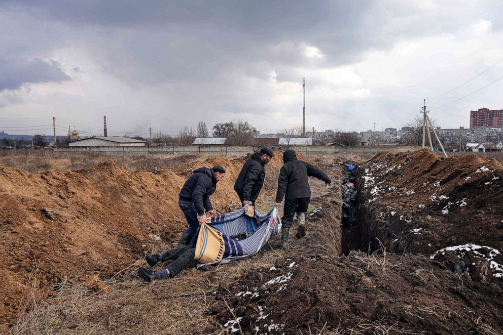 PHOTO: Dead bodies are put into a mass grave on the outskirts of Mariupol, Ukraine,  March 9, 2022, as people cannot bury their loved ones because of the heavy shelling by Russian forces.
