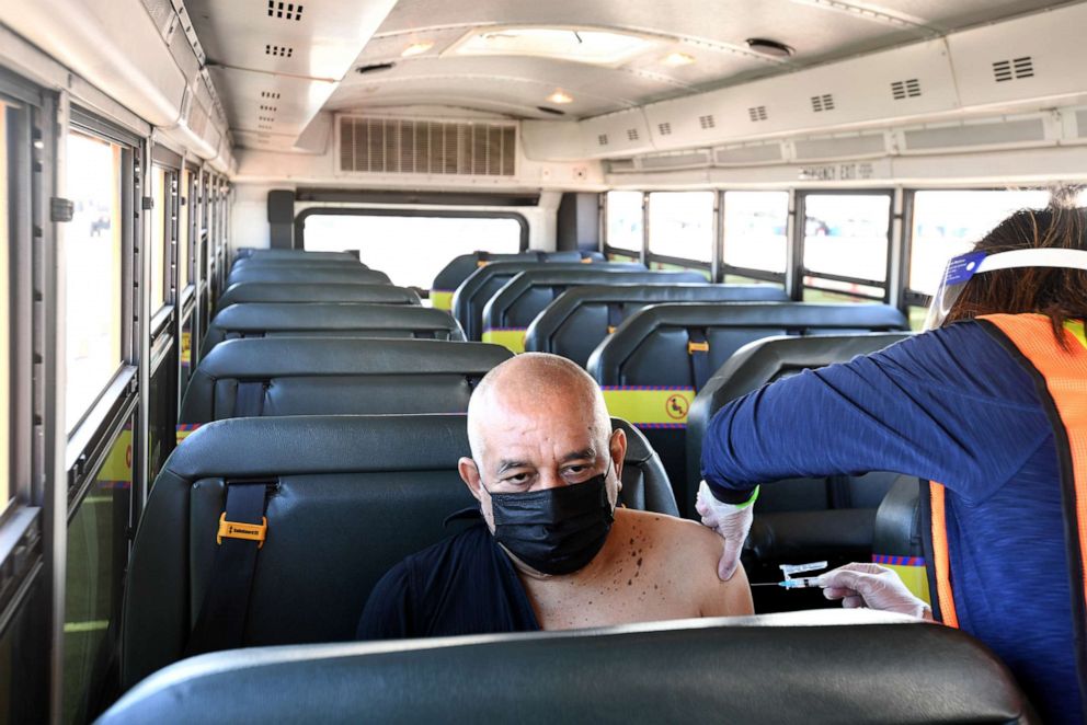 PHOTO: Rene Urey an LAUSD special education assistant gets his COVID-19 vaccine aboard a school bus that transported him to the SoFi Stadium in Inglewood, Calif. on March 1, 2021.