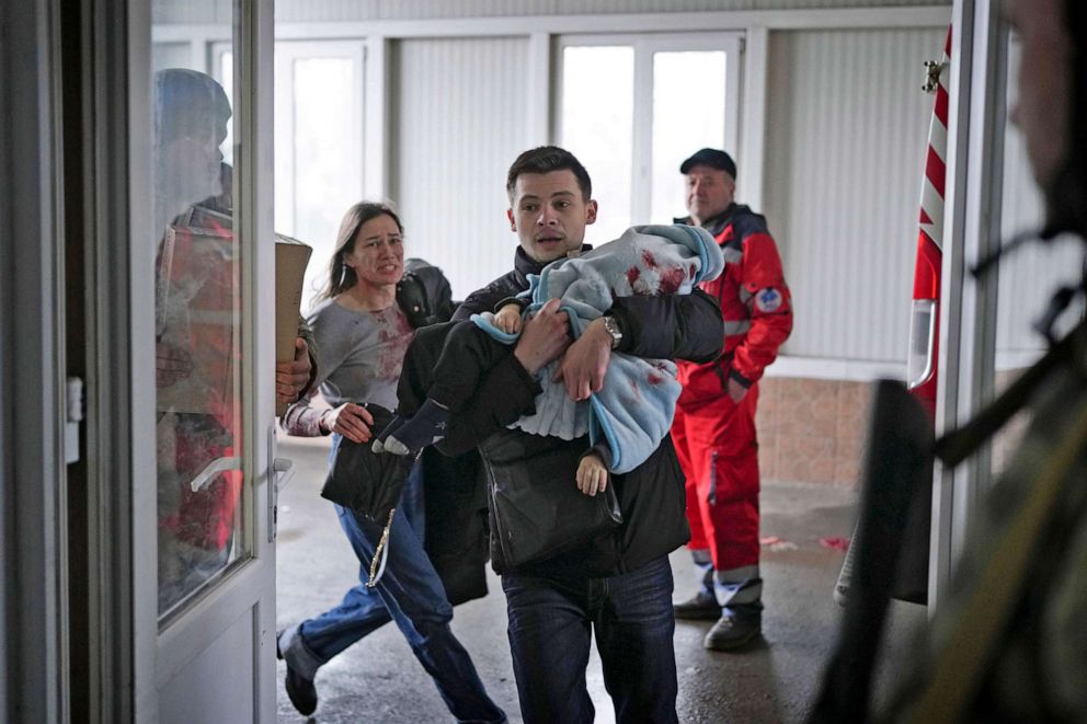 PHOTO: Marina Yatsko, left, runs behind her boyfriend Fedor carrying her 18 month-old son Kirill who was fatally wounded in shelling, as they arrive at a hospital in Mariupol, Ukraine, March 4, 2022. 