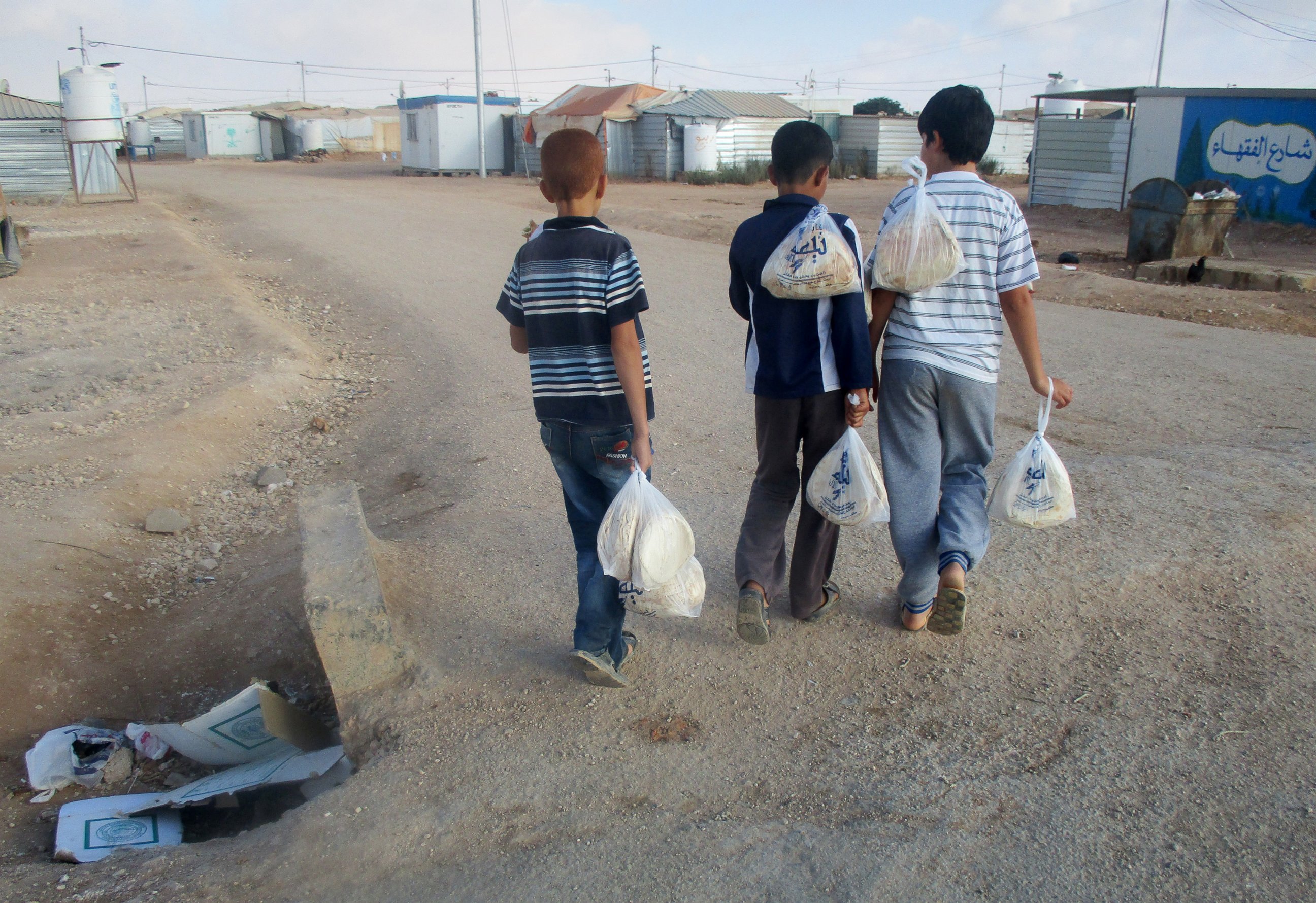PHOTO: Children carry bread home. We go to the WFP center every morning around 7 a.m. to get bread. 
