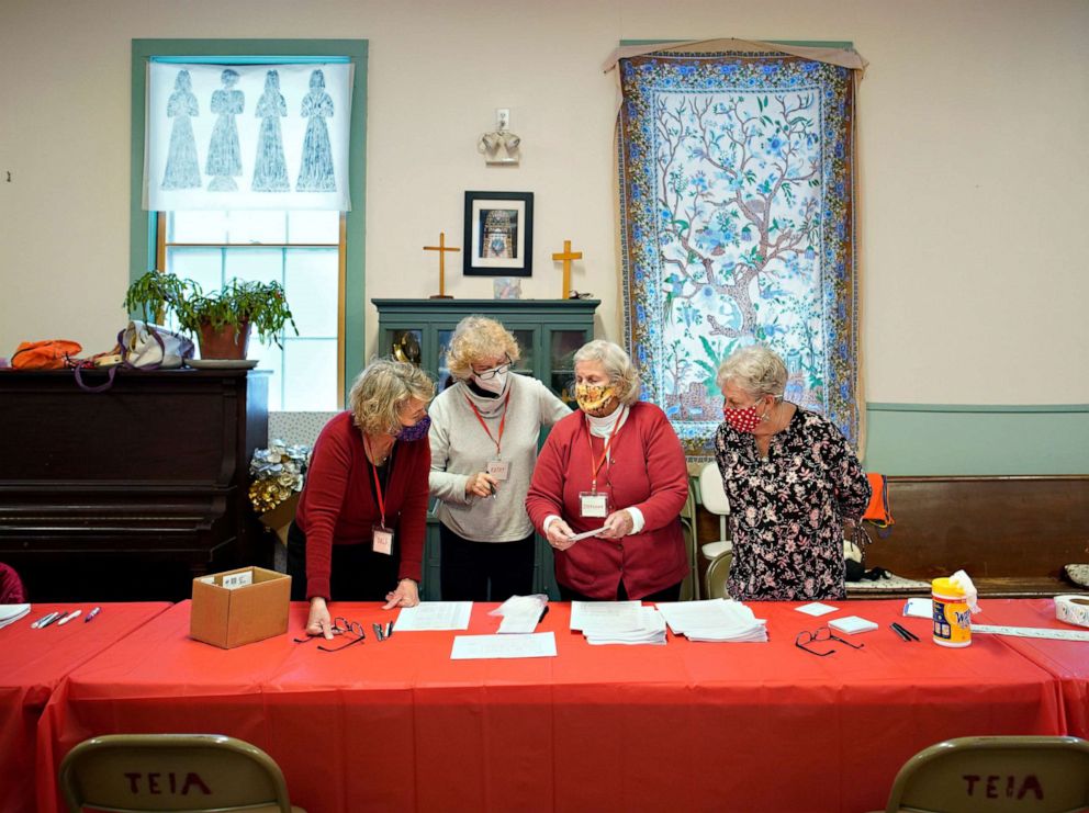 PHOTO: Peaks Island residents Lois Tiedeken, Kathy McCarthy, Stephanie Castle and Judy Nelson, left to right, talk about intake paperwork prior to the start of an immunization clinic at Brackett Memorial Methodist Church on Peaks Island, Feb. 14, 2021.