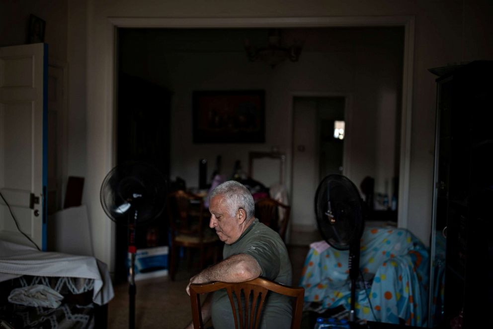PHOTO: Tony Matar, 68, sits on a chair in the living room of his home in Karantina, Beirut, Aug. 13, 2020.