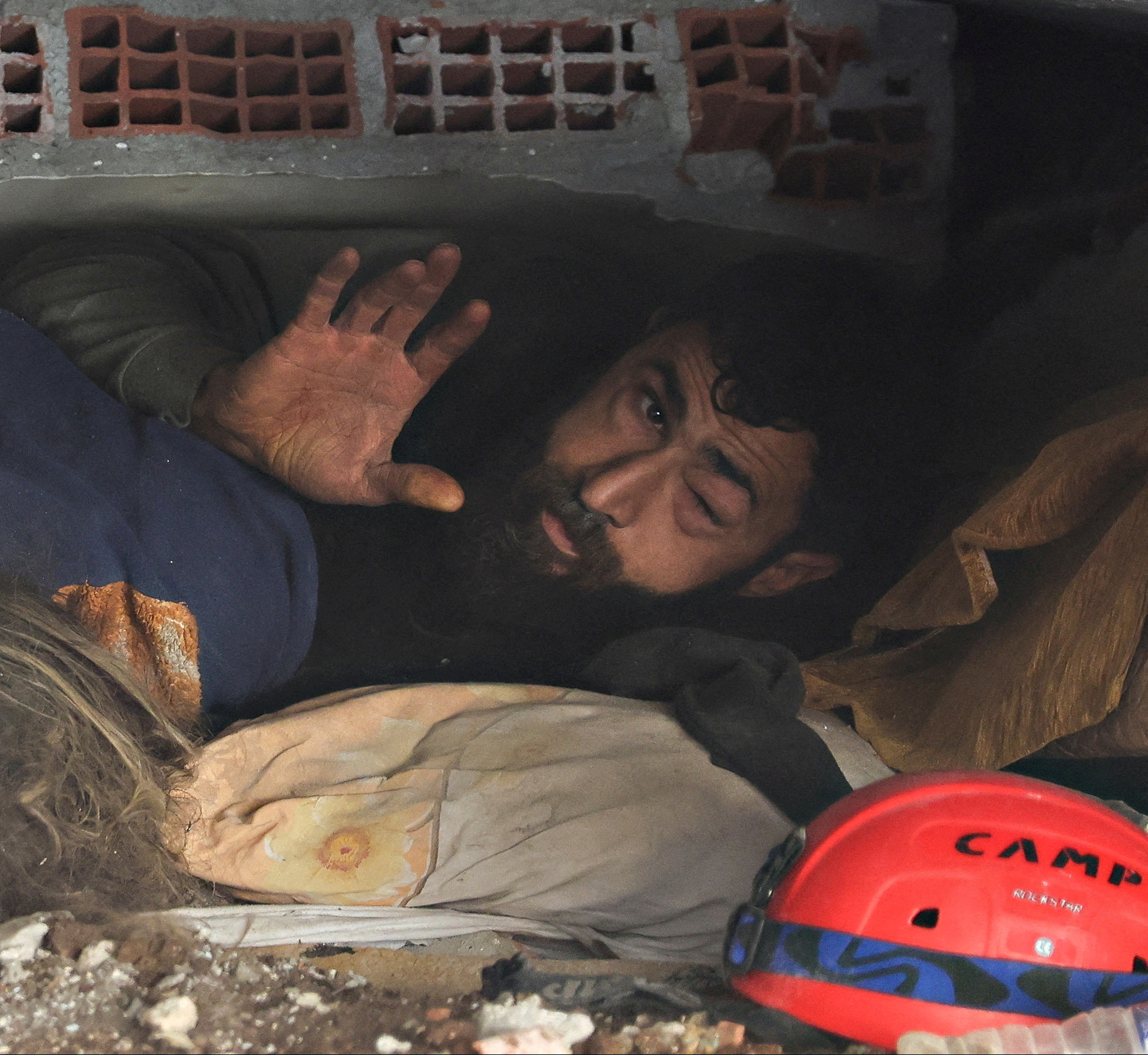 PHOTO: Abdulalim Muaini lies under the rubble next to the body of his wife Esra, in Hatay, Turkey, Feb. 8, 2023.