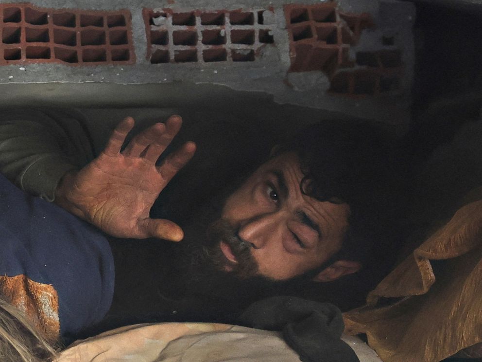 PHOTO: Abdulalim Muaini lies under the rubble next to the body of his wife Esra, in Hatay, Turkey, Feb. 8, 2023.