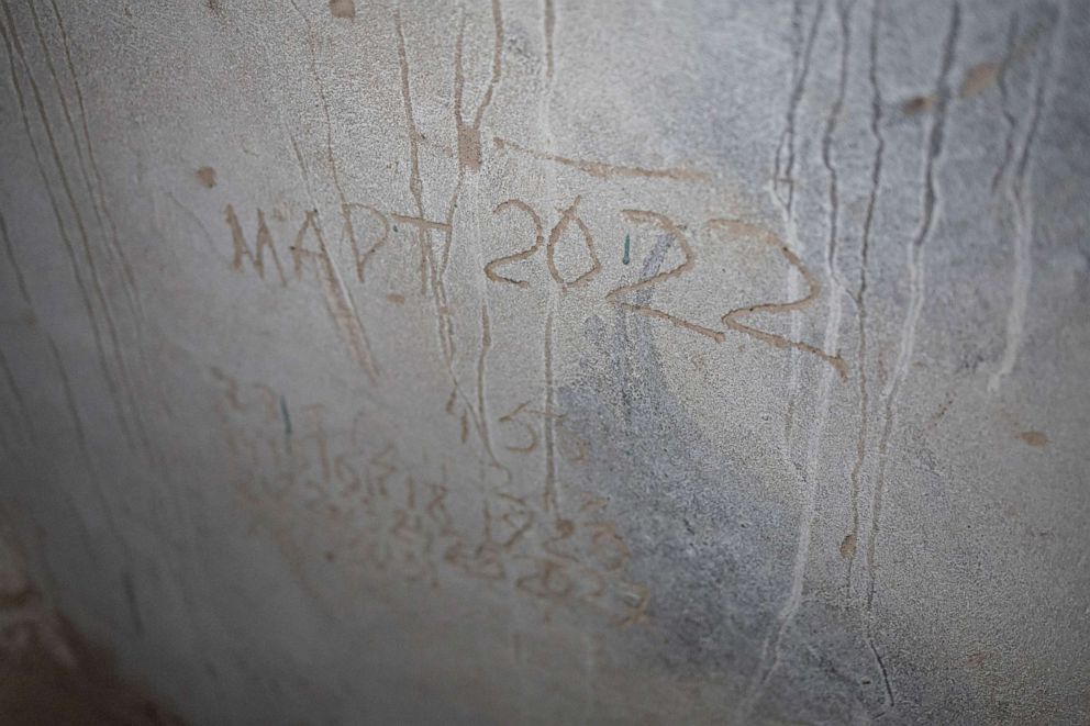 PHOTO: The words "March 2022" are scratched into a wall inside the basement of the school.