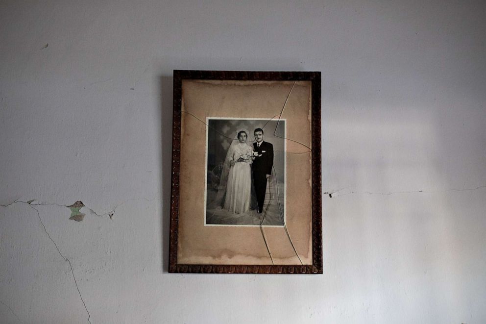 PHOTO: A broken framed photograph of Marguerite Dirany and her husband Elie hangs on a wall in her home in Karantina, Beirut, Aug. 12, 2020.