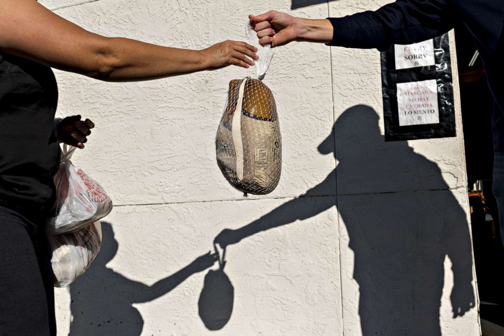 PHOTO: A person hands over a turkey at the Bay Area Rescue Mission's Thanksgiving Giveaway in Richmond, Calif. on Nov. 24, 2020.