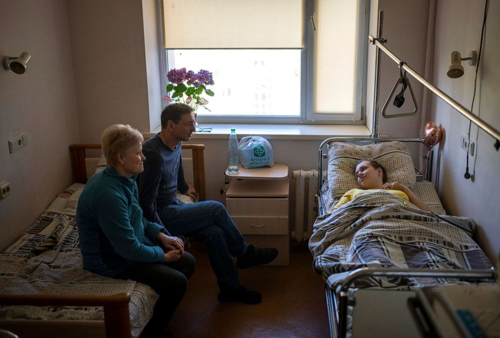 PHOTO:  Nastia Kuzik, 21, talks with her parents while waiting to be transported to Germany from a hospital in Kyiv, Ukraine, May 5, 2022. She lost her right leg below the knee and seriously injured her left, after beig caught by bombing on March 17. 