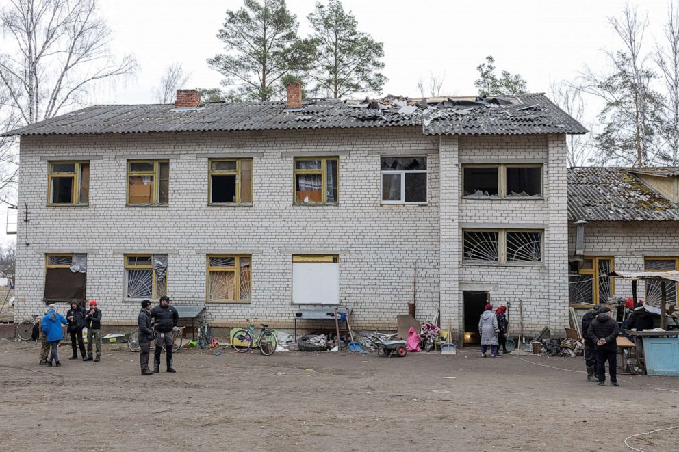 PHOTO: People stand in front of the damaged school.