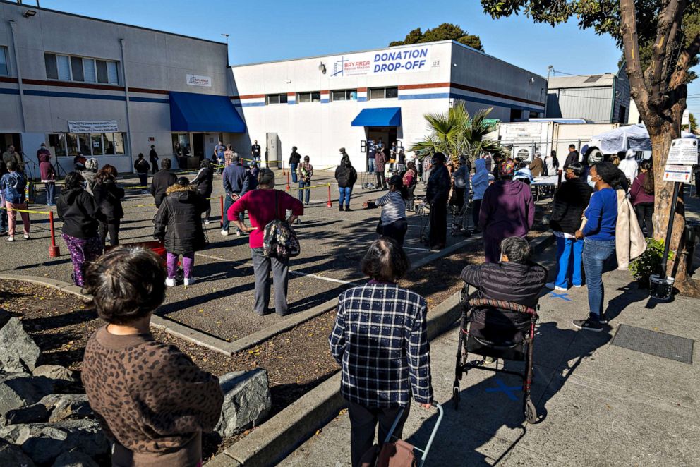 PHOTO: People wait in line to receive food at the Bay Area Rescue Mission's Thanksgiving Giveaway in Richmond, Calif. on Nov. 24, 2020.