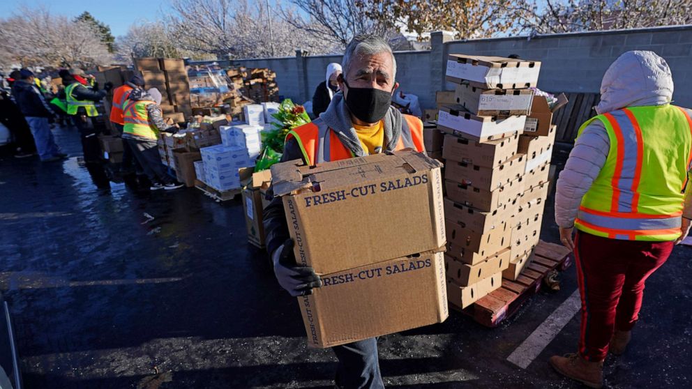 PHOTO: A volunteer carries food to waiting cars at the Utah Food Bank's mobile food pantry, Nov. 12, 2020, in West Valley City, Utah.