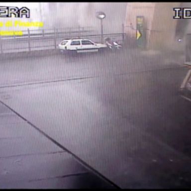 A security camera shows vehicles below the bridge in Genoa as it collapses and creates a cloud of dust.