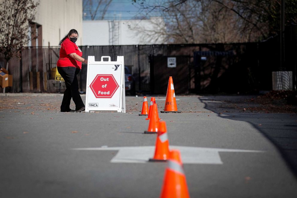 PHOTO: A volunteer moves an "out of food" sign during the Meadowlands Area YMCA and the Community Food Bank of New Jersey food drive ahead of the Thanksgiving holiday, during the COVID-19 pandemic, in East Rutherford, N.J., Nov. 24, 2020.
