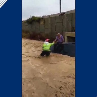 Firefighters found the man perched on the roof of his car as stormy weather brought in record rainfall.