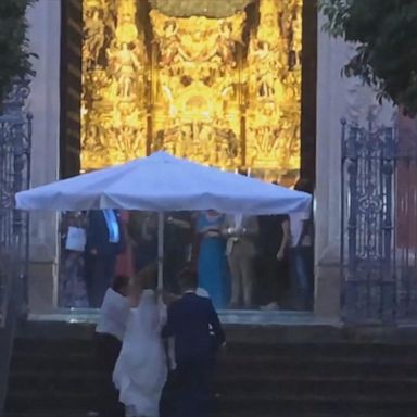 VIDEO: Waiters use giant restaurant parasol to shield bride from rain in Seville