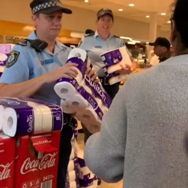 At a supermarket in Sydney, police officers handed out toilet paper and paper towels in an effort to calm coronavirus-induced stockpiling.