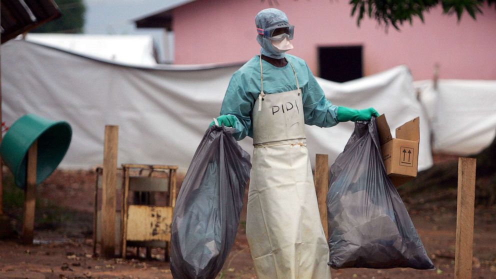 PHOTO: In this April 20, 2005 file photo a health worker in protective clothing carries waste for disposal outside the isolation ward where victims of the deadly Marburg virus are treated in the northern Angolan town of Uige.