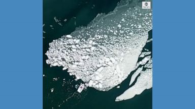 A drone captured a lone boater pushing ice away from an island on the coast of Finland.