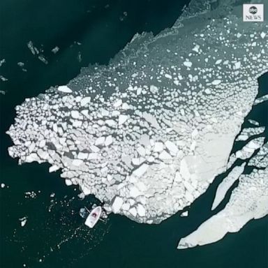 A drone captured a lone boater pushing ice away from an island on the coast of Finland.