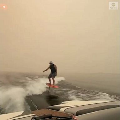 A surfer rode a hydrofoil surfboard over Shuswap Lake, covered by thick smoke caused by the Two Mile Road fire in British Columbia.