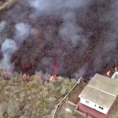 Drone video shows lava flowing into fields and inhabited areas of Spain's La Palma island, where a volcanic explosion destroyed at least 100 homes.