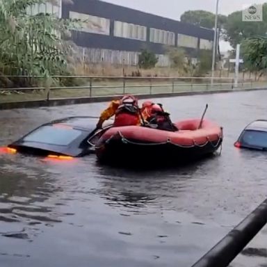 Firefighters used an inflatable to rescue two drivers whose cars were almost entirely underwater following flooding in Forli, Italy.