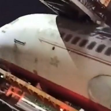 An Air India aircraft gets stuck under a pedestrian footbridge while being transferred outside the New Delhi airport in India.