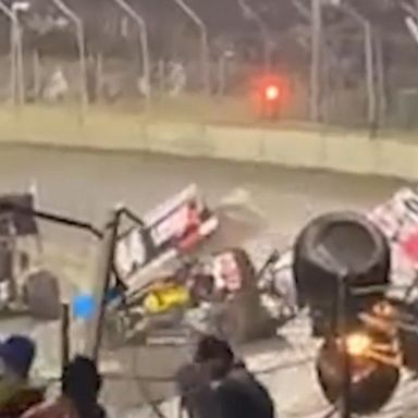 Spectators scramble for cover as a car flies through the air following a crash at a racetrack in Australia. The drivers and spectators escaped injury.