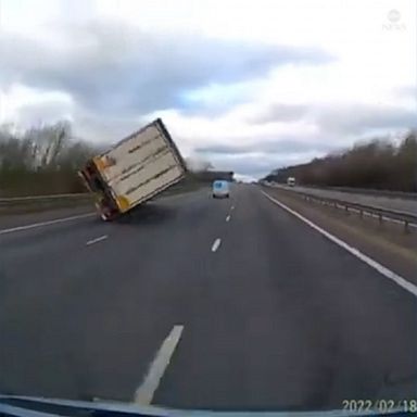 A powerful gust of wind overturned a truck on a motorway in the U.K., narrowly missing a van driving alongside it.