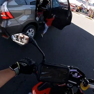 Dramatic video shows the moment the door of a vehicle on a busy road in Mexico swings open and a child falls out, clinging to the car. The child was safely pulled back in.