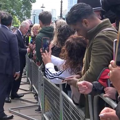 Their visit surprised mourners who were in line to view the late queen's coffin. 