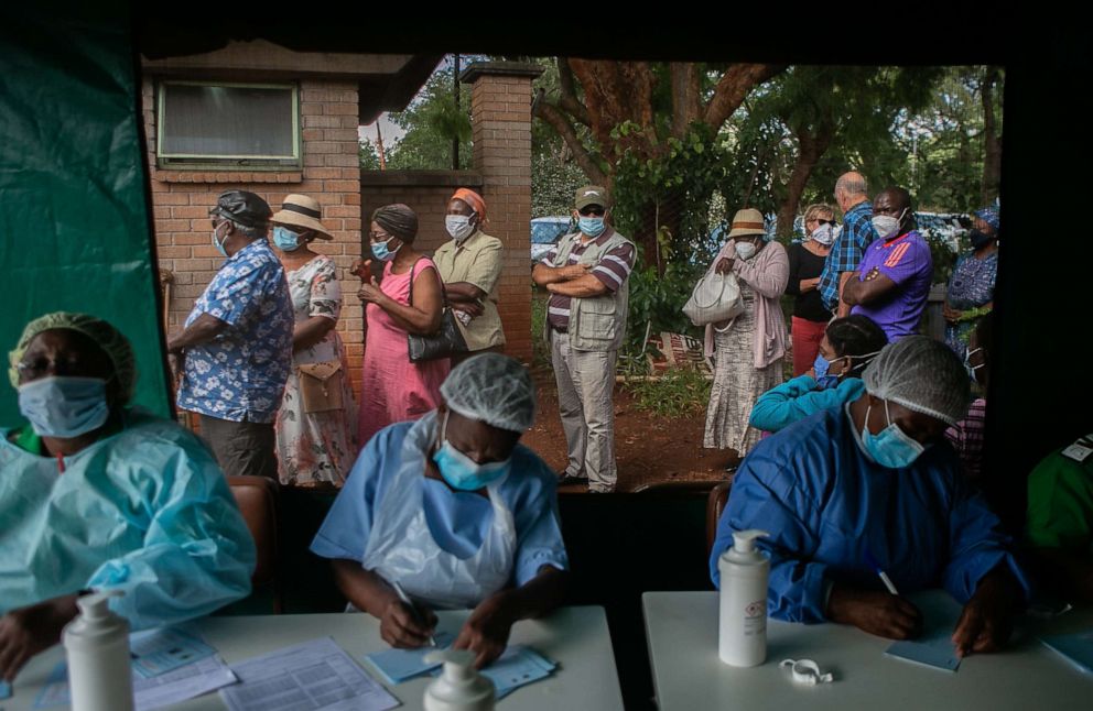PHOTO: Elderly people queue for the Sinopharm COVID-19 vaccination outside the tent while nurses conduct their duties at a local hospital on March 29, 2021, in Harare, Zimbabwe.