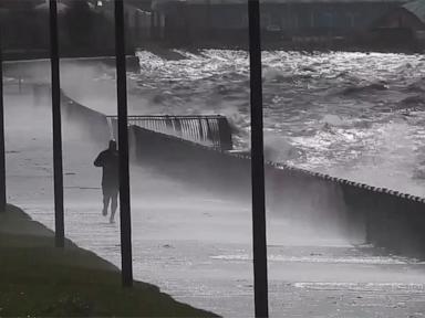 WATCH:  Man calmly jogs along oceanfront as storm rages