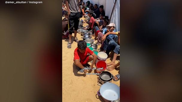 Children wait for food by community kitchen in Gaza