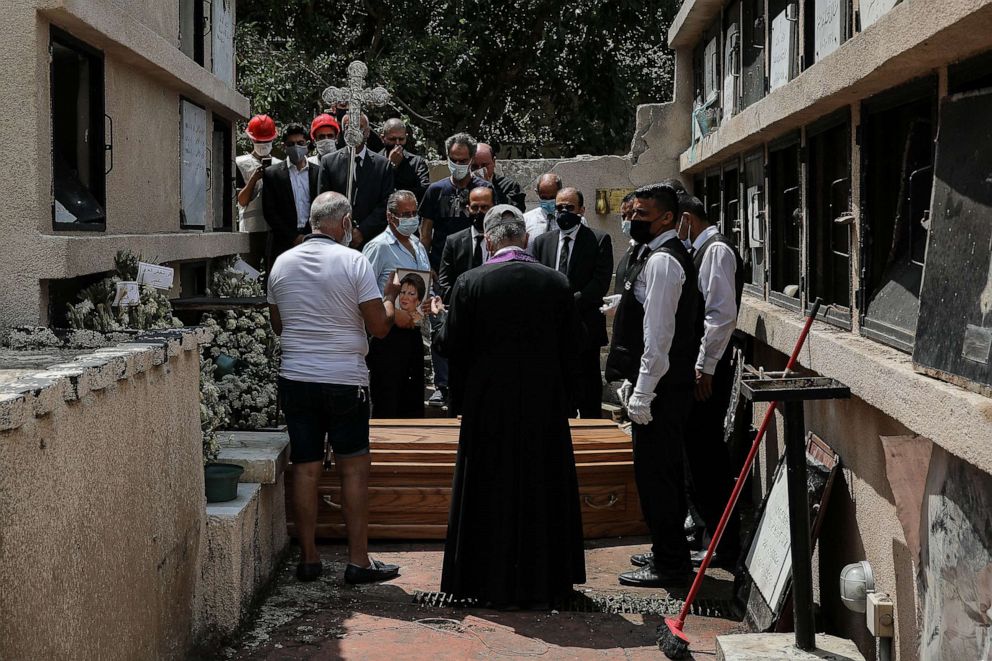 PHOTO: People attend the funeral of Claudette Halabi, who was killed in the port explosion, at a cemetery that was also damaged by the blast, in Beirut, Aug. 11, 2020.