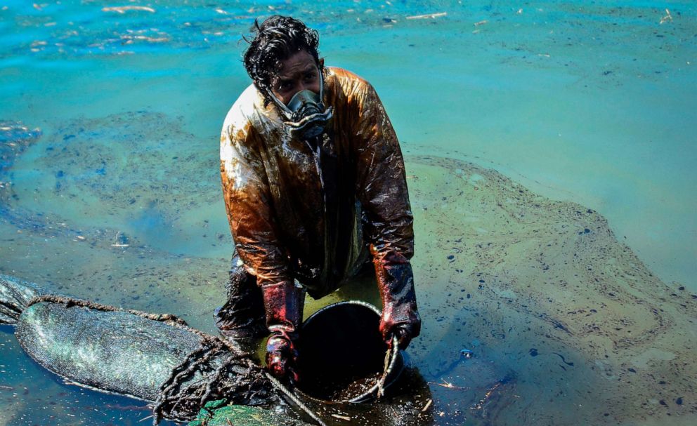 PHOTO: A man scoops leaked oil from the MV Wakashio off the coast of south-east Mauritius on Aug. 8, 2020.