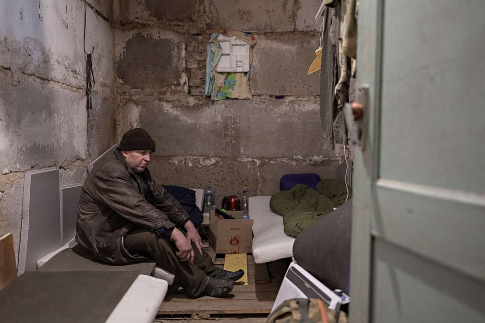 PHOTO: Serhii Bondarenko sits inside a room in the basement of the school. 