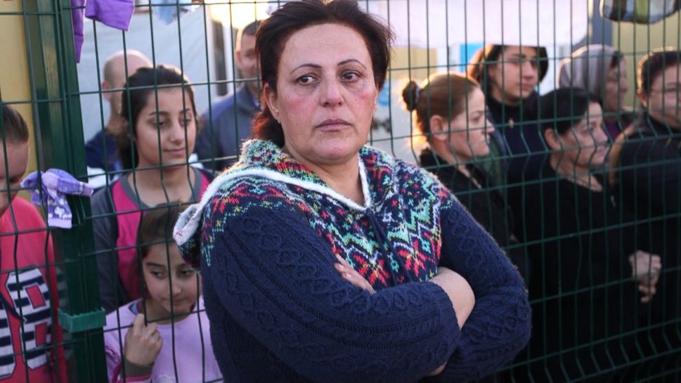 Majida Habeeb Gorgees, the cook for the refugee center in Erbil, Iraq, stands by a fence.