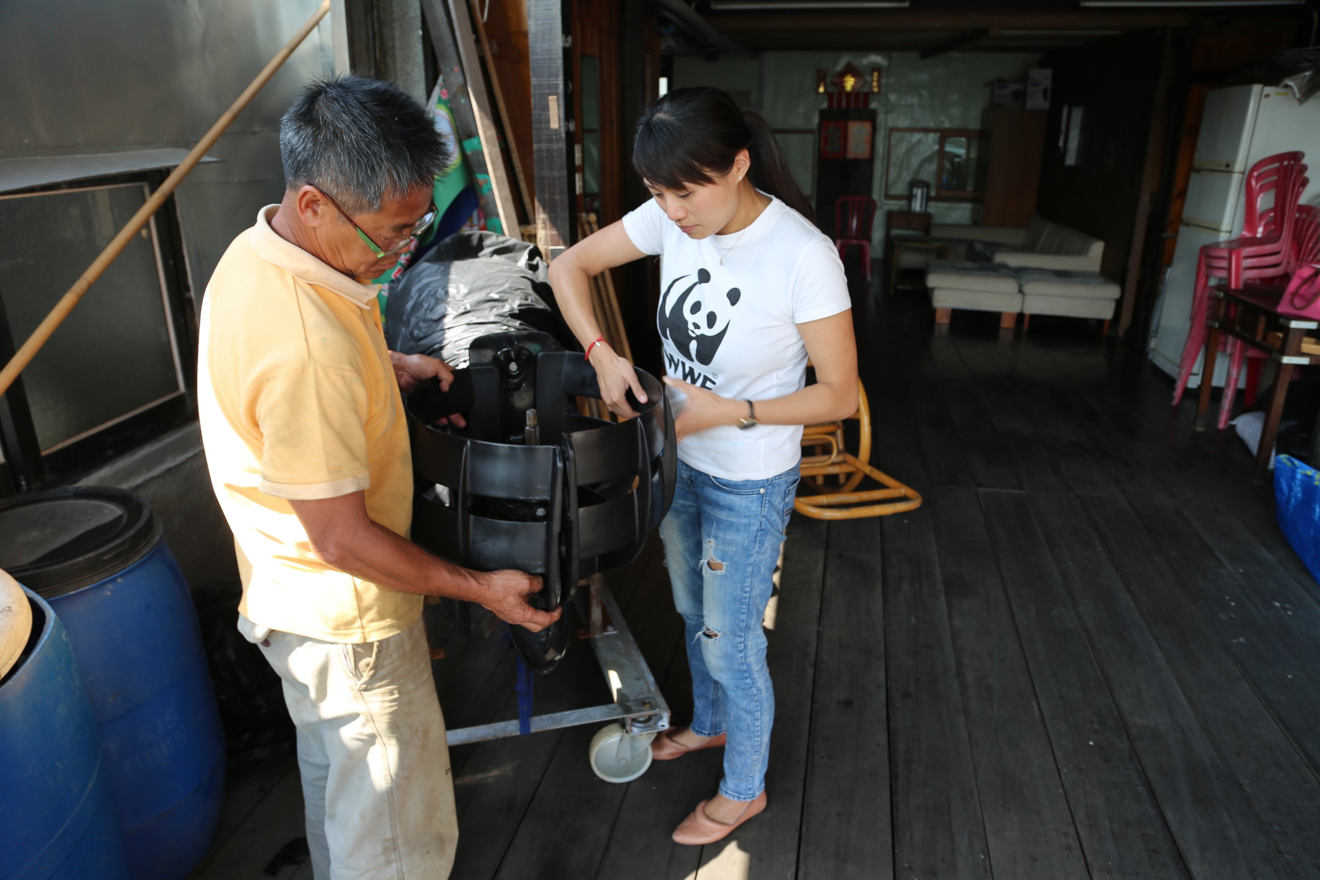 PHOTO: Samantha Lee assists local fisherman place propeller guards to avoid hitting dolphins. 