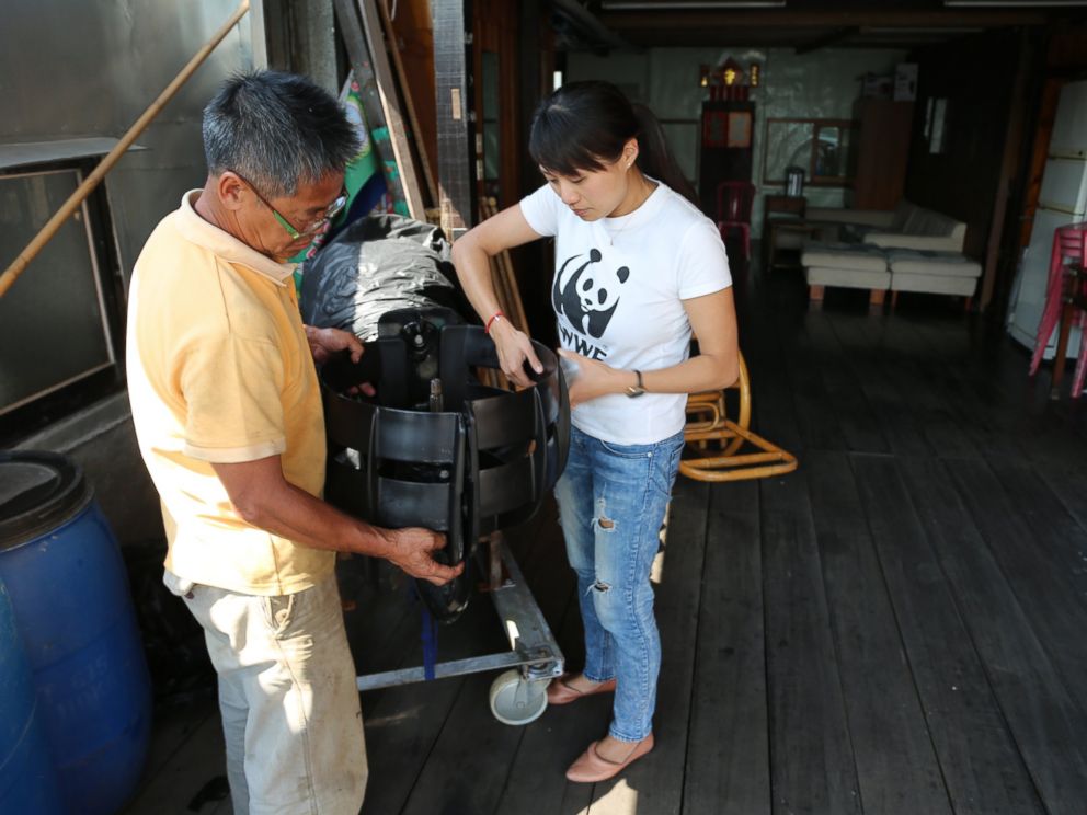 PHOTO: Samantha Lee assists local fisherman place propeller guards to avoid hitting dolphins.
