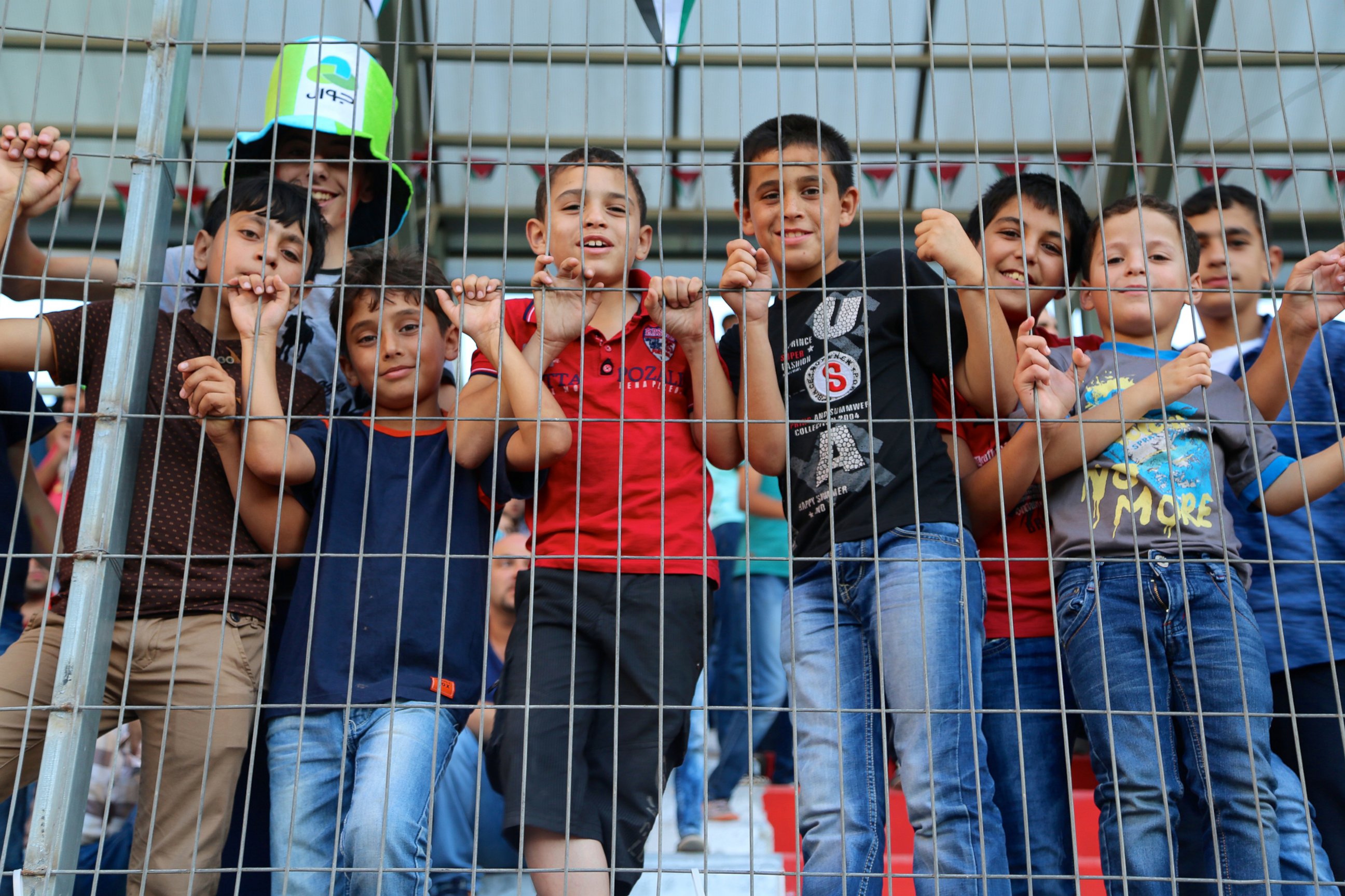 Young football fans in the stands at the Palestine Cup final match.