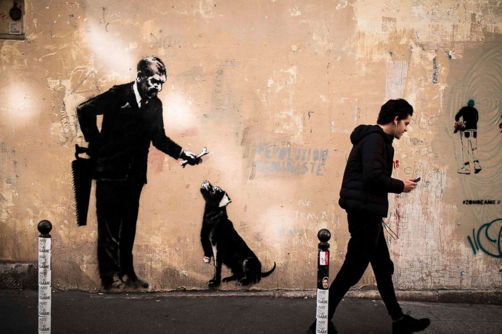 PHOTO: A man walks past a recent artwork by street artist Banksy in Paris on June 24, 2018.