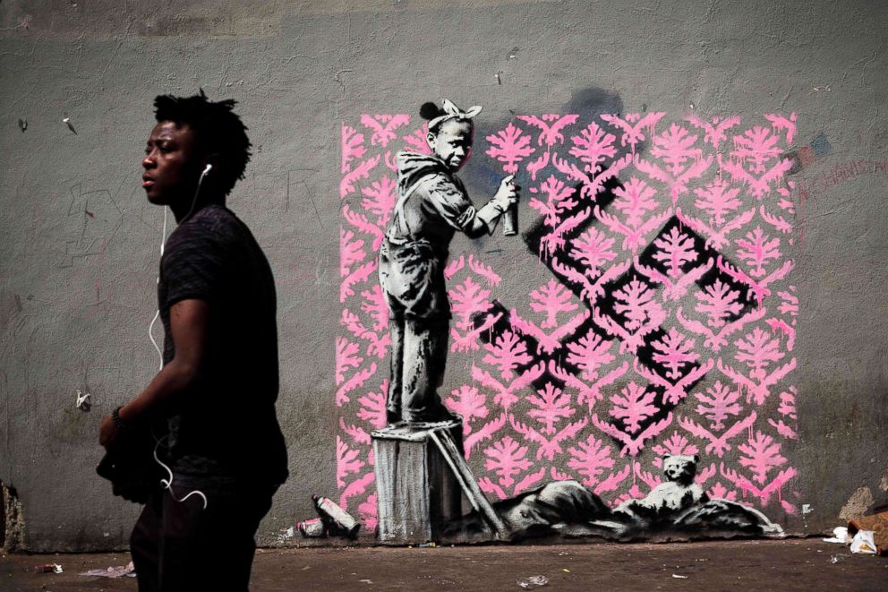 PHOTO: A man walks past a recent artwork by street artist Banksy in Paris on June 24, 2018. 