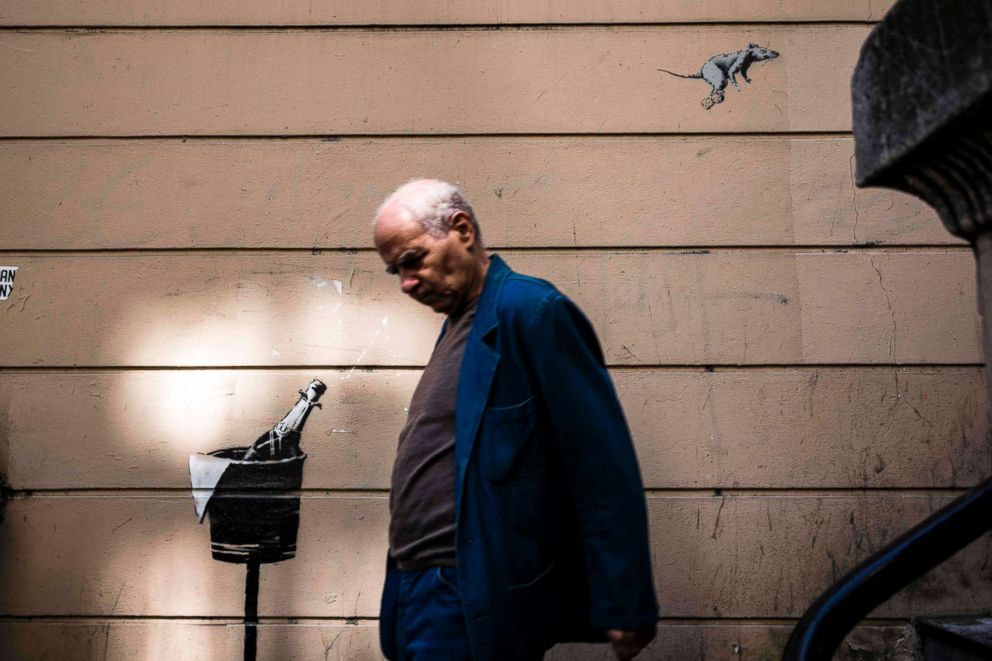 PHOTO: A man walks past a recent artwork by street artist Banksy in Paris on June 25, 2018.