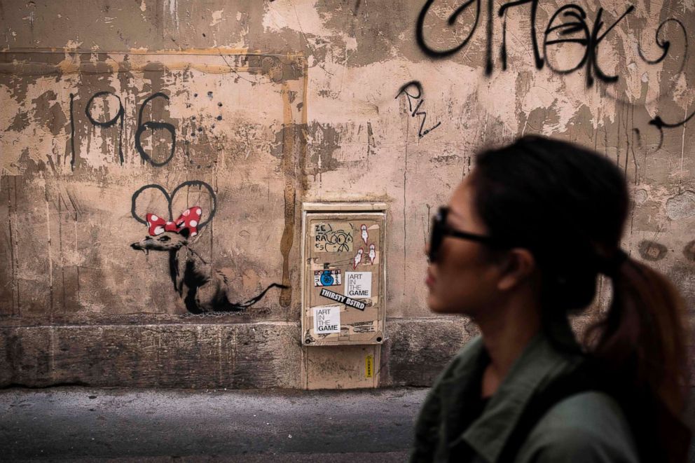 PHOTO: A woman walks past a recent artwork by street artist Banksy in Paris on June 25, 2018.
