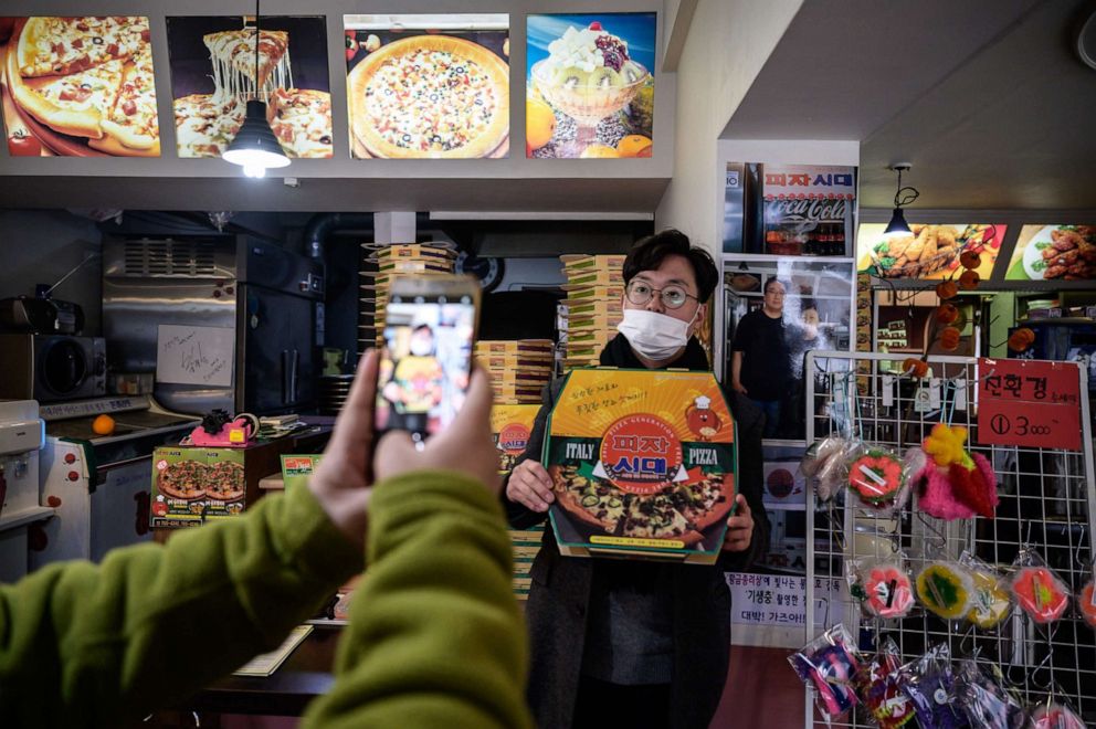 PHOTO: A customer poses before a photo of film director Bong Joon-ho at the 'Sky Pizza' restaurant in Seoul on February 13, 2020.