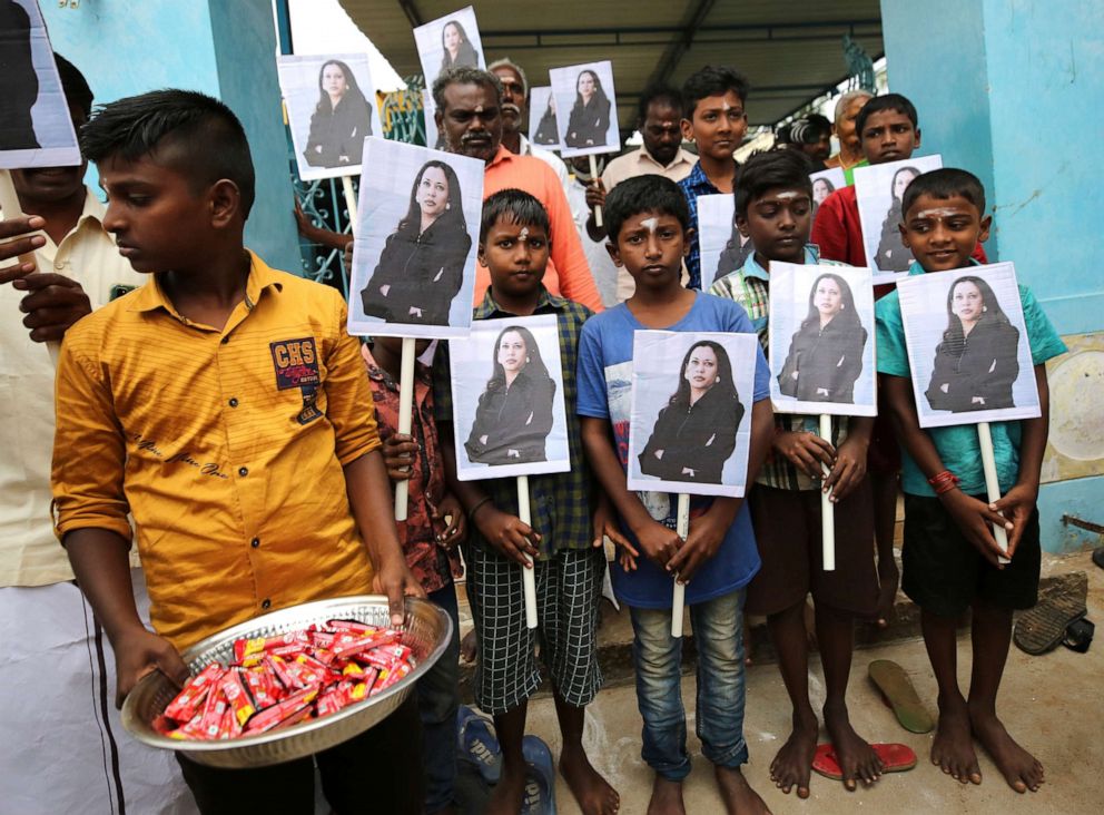 PHOTO: A child holds a tray of chocolates as others hold portraits of U.S. Vice President-elect Kamala Harris after participating in special prayers ahead of her inauguration, at a Hindu temple in Thulasendrapuram, India, on Wednesday, Jan. 20, 2021. 